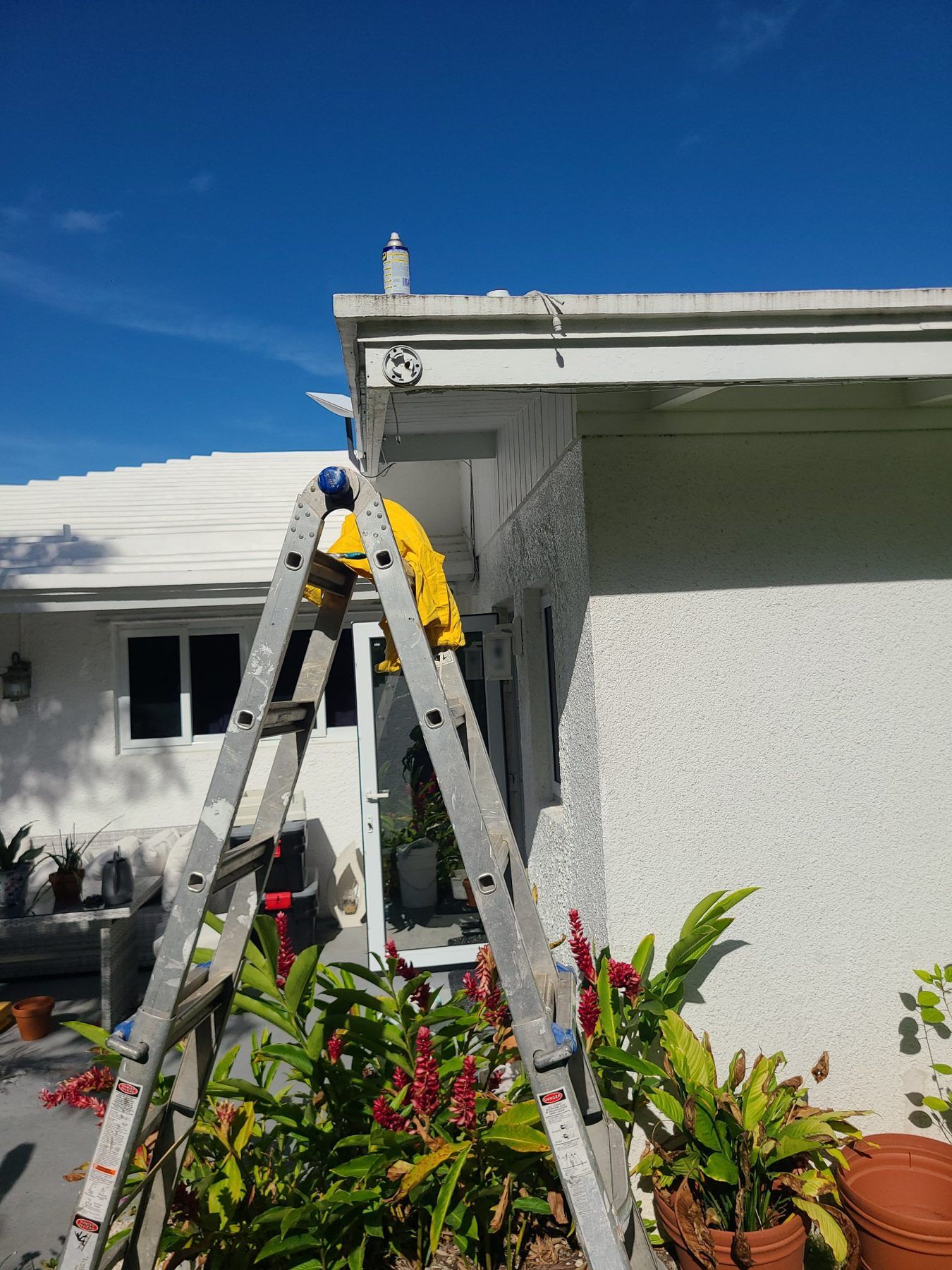 Technician on a ladder at the house